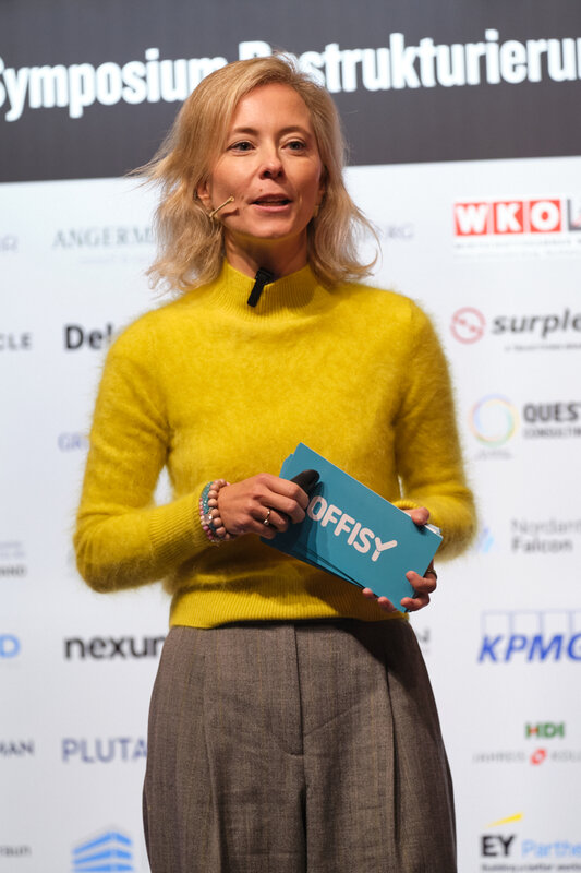 Stefanie Schauer als Speakerin auf der Bühne beim 15. Internationalen Symposium Restrukturierung 2026. 