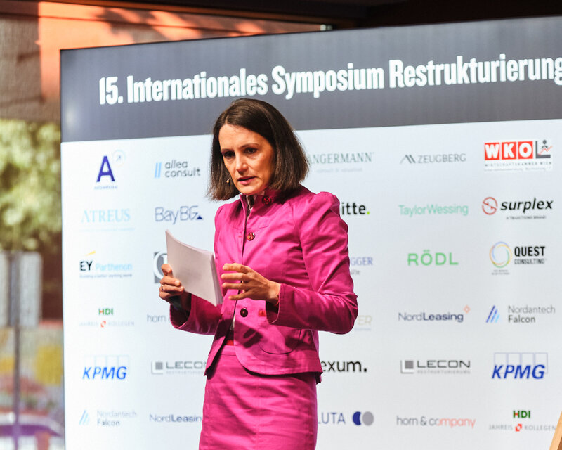 Verena Fink, auf der Bühne als Speakerin beim 15. Internationalen Symposium Restrukturierung 2026 